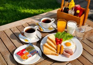 a table with plates of breakfast food and cups of coffee at Wualai Boutique by Lanna Oriental in Chiang Mai
