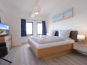 a bedroom with a large bed and a television at Ohlerich Speicher App_ 46 in Wismar