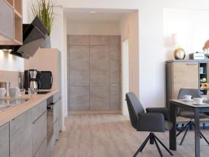 a kitchen with a table and chairs in a room at Ohlerich Speicher App_ 46 in Wismar