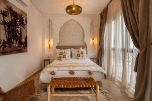 a bedroom with a bed and a large window at Riad privé Maskat, piscine, petit-déjeuners, proche Jemaa el-Fna in Marrakesh