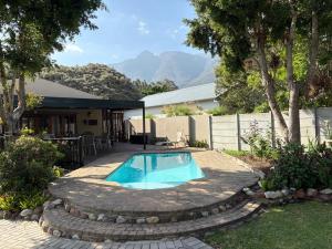 a swimming pool in a yard with a patio at Grace Walk Guest House in Swellendam