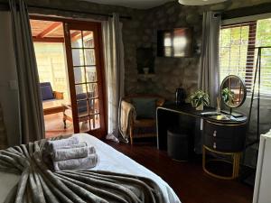 a bedroom with a bed and a desk with a mirror at Grace Walk Guest House in Swellendam +66 photos