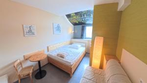 a small bedroom with a bed and a table at Babelfish Hostel in Würzburg