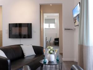 a living room with a couch and a tv on a wall at Ohlerich Speicher App_ 19 in Wismar +24 photos