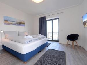 a bedroom with a bed with a desk and a chair at Ohlerich Speicher App_ 14 in Wismar +9 photos