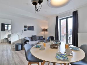 a living room with a table and chairs and a couch at Ohlerich Speicher App_ 08 in Wismar