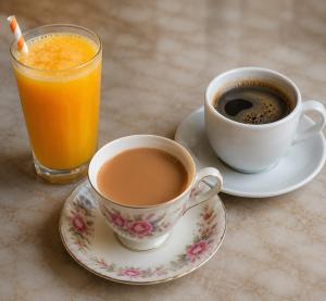 two cups of coffee and a glass of orange juice at Hotel Aura Bellamonts Near Delhi Airport- Free Airport PickUp & Drop , Breakfast & Dinner Complementary in New Delhi