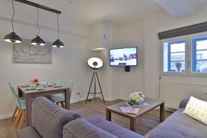 a living room with a couch and a table and a tv at Ohlerich Speicher App_ 04 in Wismar