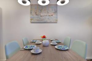 a dining room table with blue chairs and a painting at Ohlerich Speicher App_ 04 in Wismar +27 photos