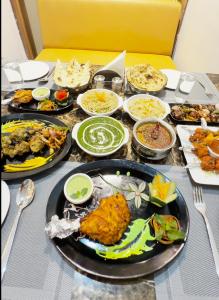 a table with many plates of food on it at Hotel Srirangasthalam in Chitradurga