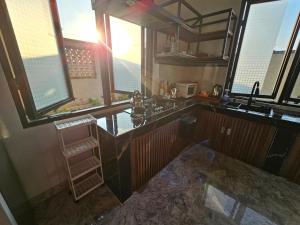 a kitchen with a sink and a counter top at Kala Senja Guest House in Sukawati