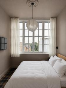 a bedroom with a large white bed and a window at The Brewhouse Hotel in Edinburgh