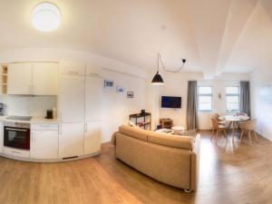 a living room with a couch and a kitchen and a table at Ohlerich Speicher App_ 25 in Wismar