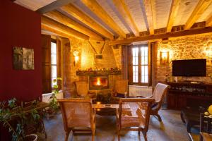 a living room with a table and chairs and a fireplace at El Señorio De La Serrezuela in Aldeanueva De La Serrezuela 