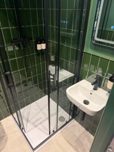 a green tiled bathroom with a sink and a shower at The Brewhouse Hotel in Edinburgh +40 photos