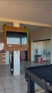 a pool table in a room with a large screen at Rancho Bela Vista in Alexânia