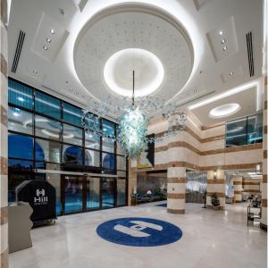 a large lobby with a chandelier in a building at HILLTOWN Hotel in Medina