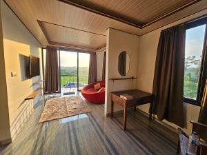 a living room with a red couch and a large window at Kala Senja Guest House in Sukawati +21 photos