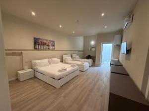 a room with two beds and a couch and a television at City Loft in Piacenza