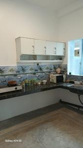 a kitchen with white cabinets and a counter top at villa calm haven in Unawatuna