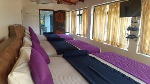 a room with a row of pillows on a couch at SD Residency - Yercaud in Yercaud +18 photos