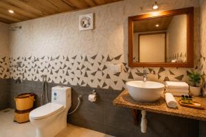 a bathroom with a toilet and a sink and a mirror at Platinum Heritage Desert Camp in Jaisalmer