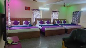 a room with three beds with purple pillows at SD Residency - Yercaud in Yercaud