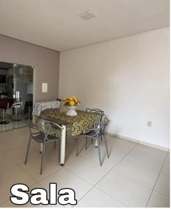 a dining room with a table and chairs with a vase on it at Casa grande e confortável! in Petrolina +7 photos