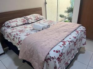 a bed with red and white blankets and pillows at Casa grande e confortável! in Petrolina