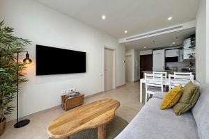 a living room with a couch and a tv on the wall at Antika Marbella 1A in Marbella