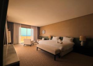 a hotel room with a large bed and a chair at The Riad by Blue Waves in Agadir