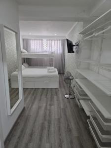 a white room with a bed and some shelves at Mikaela Guest House in Odivelas +4 photos