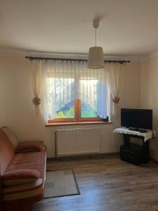 a living room with a couch and a window at Sielski domek w Orawce in Jabłonka