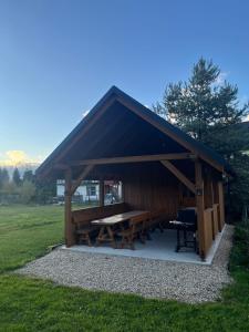 a picnic shelter with a picnic table in a field at Sielski domek w Orawce in Jabłonka