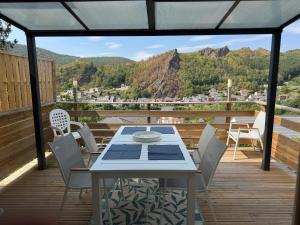 a table and chairs on a deck with a view at Chez Gwen et Marie in Bogny Sur Meuse