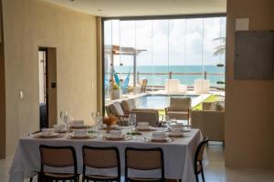 a dining room with a table and a view of the ocean at Fran de Fransquinha in Taíba