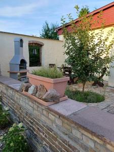 eine Backsteinmauer mit einem Pflanzkübel vor einem Haus in der Unterkunft Auszeit im Oderbruch in Letschin + 5 Fotos