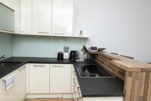 a kitchen with white cabinets and a wooden counter top at Dream Getaway Apartment with Jacuzzi and Pool in Vienna