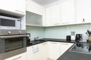 a kitchen with white cabinets and a microwave at Dream Getaway Apartment with Jacuzzi and Pool in Vienna
