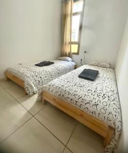 two twin beds in a room with a window at Casa Vega in El Cotillo