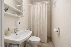 a white bathroom with a sink and a toilet at Stølsdokken Lodge in Sanderstølen