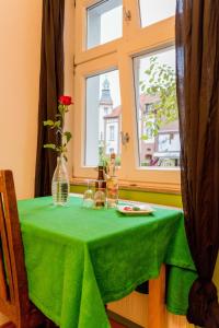 a table with a green table cloth and a window at finkeshaus in Lüdinghausen