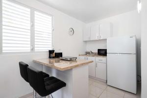 a white kitchen with a refrigerator and a counter at Colmado by Otium in Hato Candal
