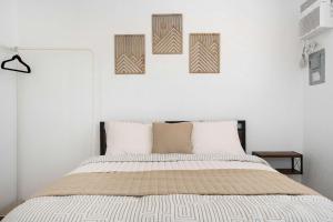 a bedroom with a bed with three pictures on the wall at Colmado by Otium in Hato Candal +59 photos