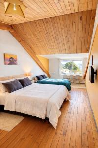 a bedroom with a large bed with a wooden ceiling at Hostal Boutique F in El Quisco