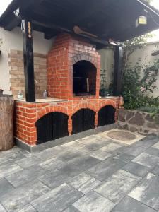 an outdoor pizza oven with a brick wall at Casa Meresanu in Zărneşti