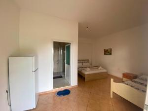 a room with two beds and a large mirror at Vila zaho in Dhërmi