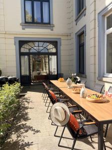 a long wooden table and chairs on a patio at Chateau entierement privatise in Hannut
