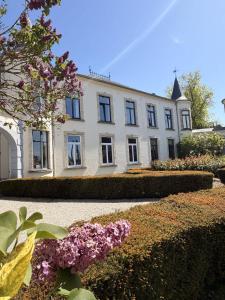 a large white house with flowers in front of it at Chateau entierement privatise in Hannut
