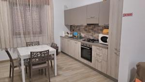 a kitchen with a table and a stove top oven at La casa rossa in Siderno Marina
